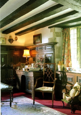 The drawing Room with wooden beams and a desk lit with a table lamp