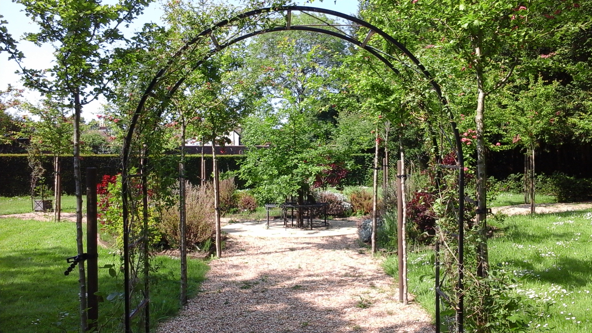 A view of the King's Garden through a metal rose arch