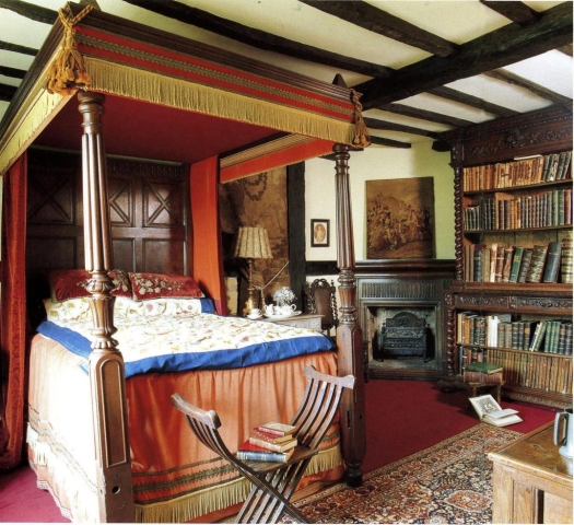 The four poster bed, a bookcase and a firelplace in the King's Room