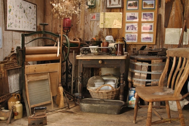 A cosy scene with a wooden table and chair and kitchen items in the rural museum
