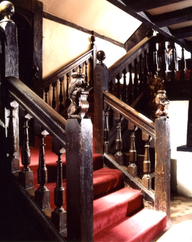 The stairs with wooden carved furniture and a red carpet